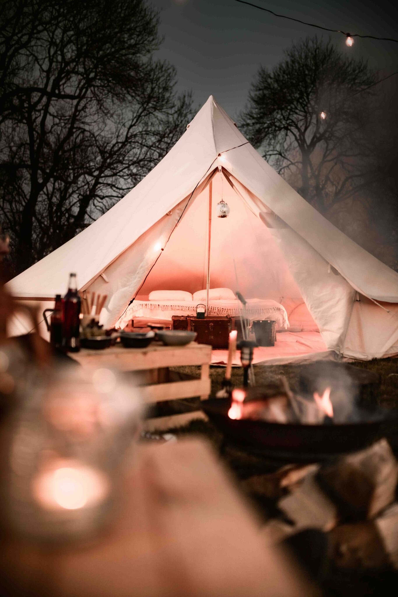 22. 5 metre bell tent lit by campfire for glamping experience